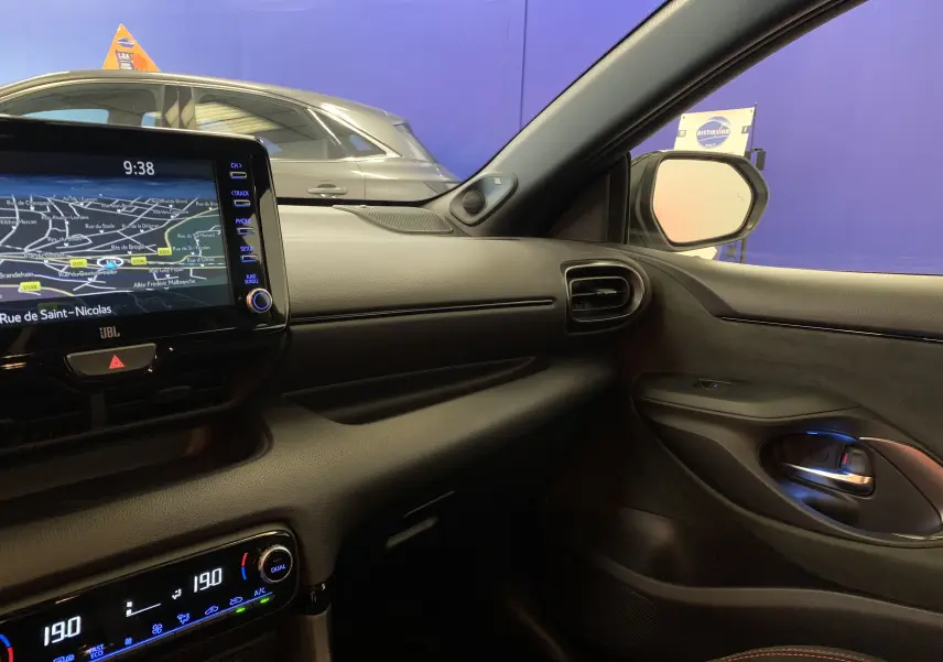 Vue intérieure côté passager de la Toyota Yaris 1.6 VVT-I 261 Premium GR avec tableau de bord noir et écran GPS tactile.