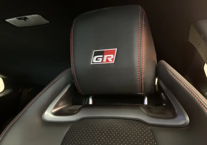 Gros plan sur l'appuie-tête noir avec logo GR et surpiqûres rouges de la Toyota Yaris 1.6 VVT-I 261 Premium GR.