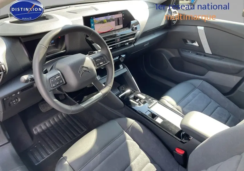 Intérieur de la Citroën C4 2024 en gris, vue côté conducteur avec volant multifonction et écran tactile central.