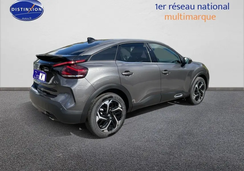 Vue 3/4 arrière droite d'une Citroën C4 2024 gris platinium métal avec jantes biton et feux arrière LED distinctifs.