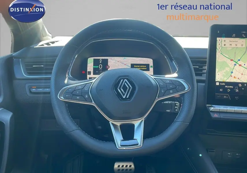 Volant en cuir noir avec commandes intégrées du Renault Captur E-Tech hybride 2025, tableau de bord digital et écran tactile.