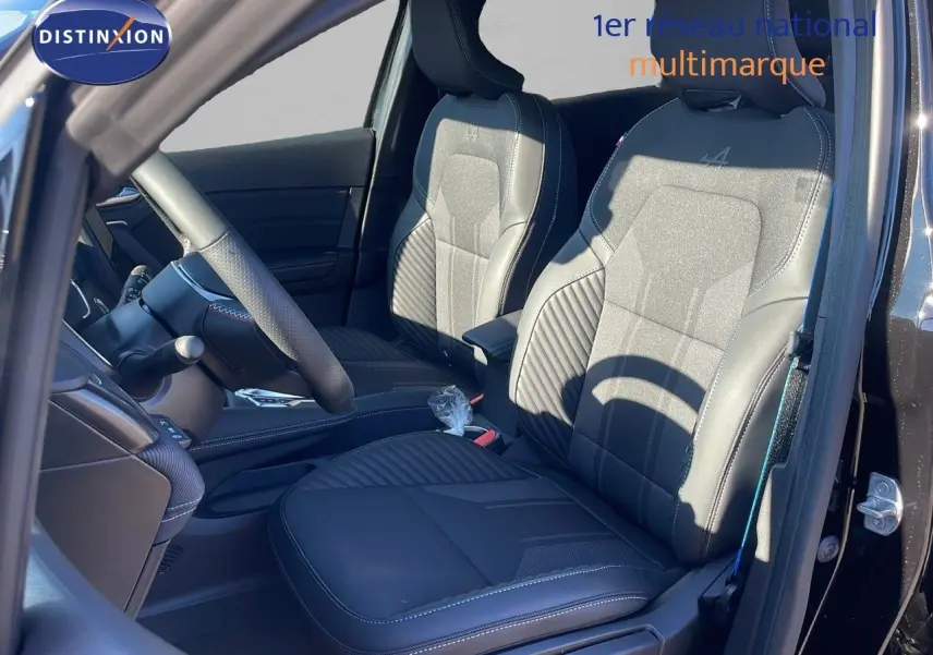 Vue intérieure côté conducteur du Renault Captur E-Tech hybride 2025 avec sièges noirs en cuir et tissu Alpine.