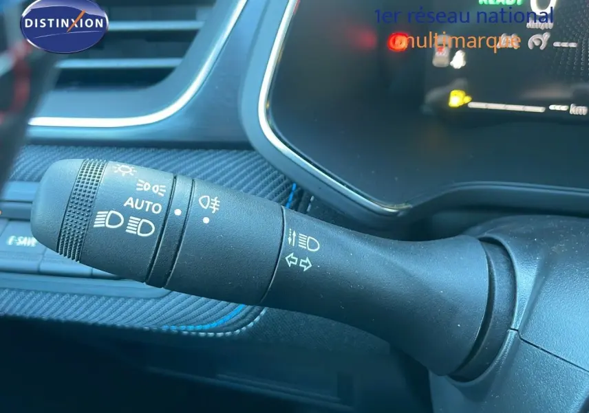 Gros plan sur la commande des phares et clignotants du Renault Captur noir étoile métal 2025, version hybride.