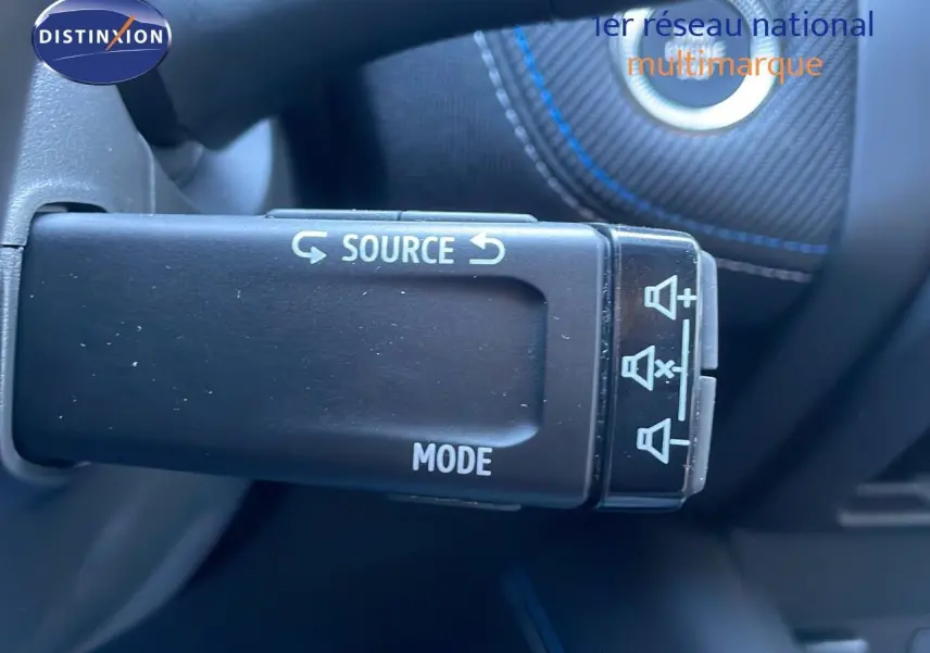 Gros plan sur la commande au volant du Renault Captur noir étoile métal, avec boutons source et mode visibles.