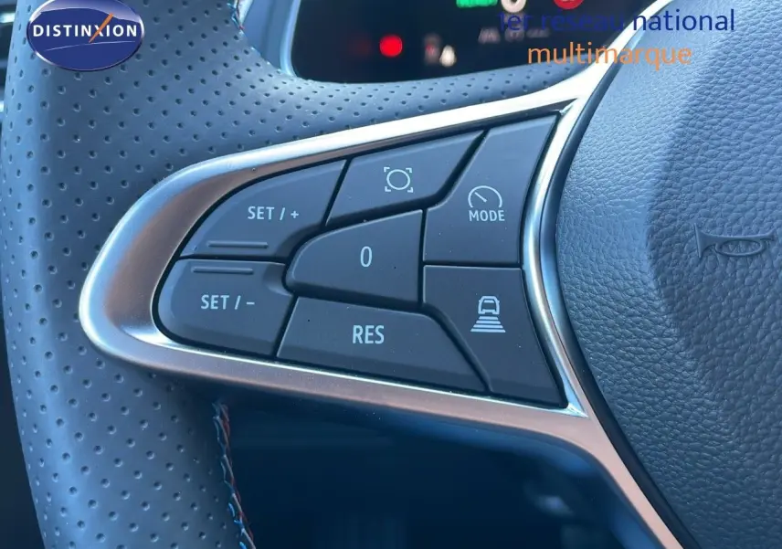 Gros plan sur les commandes du volant en cuir noir perforé du Renault Captur E-Tech hybride 2025, version Esprit Alpine.
