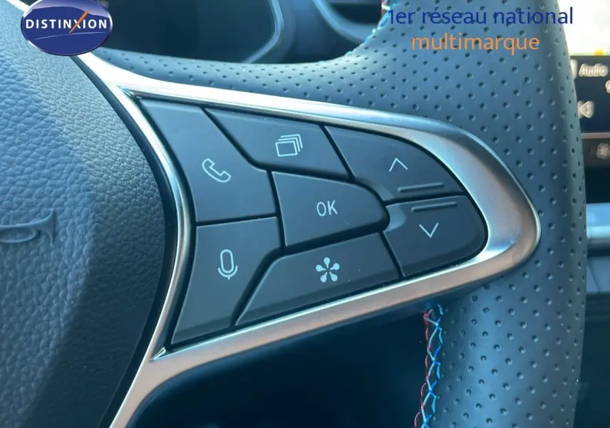 Gros plan sur les commandes multifonctions du volant perforé du Renault Captur E-Tech hybride noir étoile métal 2025.