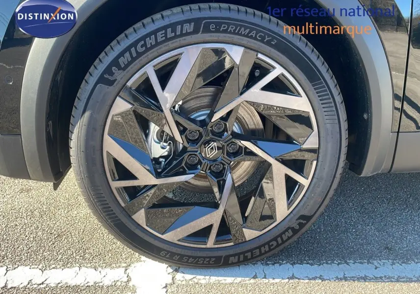 Gros plan sur la roue avant gauche du Renault Captur noir étoile métal avec jante alu au design géométrique.