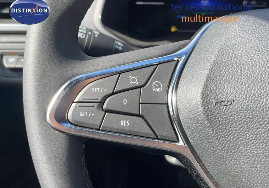 Gros plan sur les commandes du volant du Renault Captur E-Tech hybride 2025, finition noire avec insert chromé.