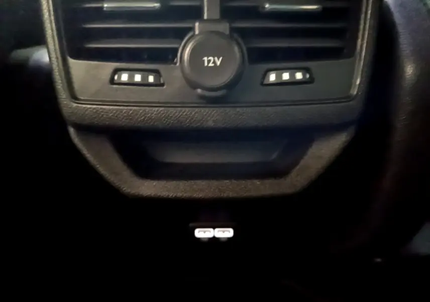 Gros plan sur la prise 12V et les ports USB arrière du Peugeot 3008 PureTech 130 GT, intérieur noir.