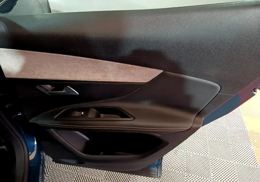 Détail de la porte avant gauche noire avec insert tissu beige du Peugeot 3008 bleu, version GT 2021.