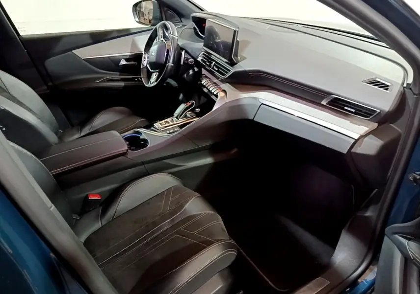 Vue intérieure côté conducteur du Peugeot 3008 bleu, avec sièges cuir noirs et tableau de bord moderne équipé d’un écran tactile.