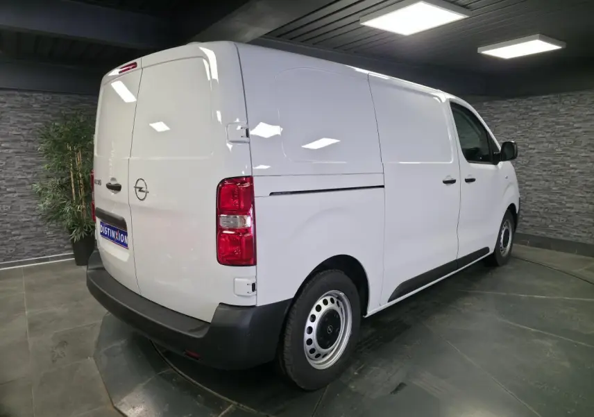 Vue 3/4 arrière droite d’un Opel Vivaro blanc, fourgon utilitaire avec portes arrière battantes et jantes tôles grises.