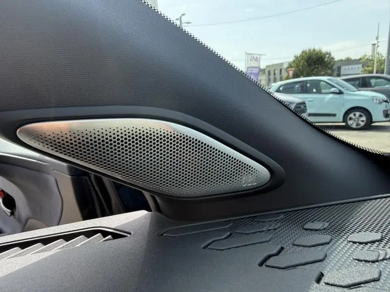 Détail du haut-parleur JBL intégré côté droit du tableau de bord d’un Toyota C-HR Hybride bleu persan 2024.