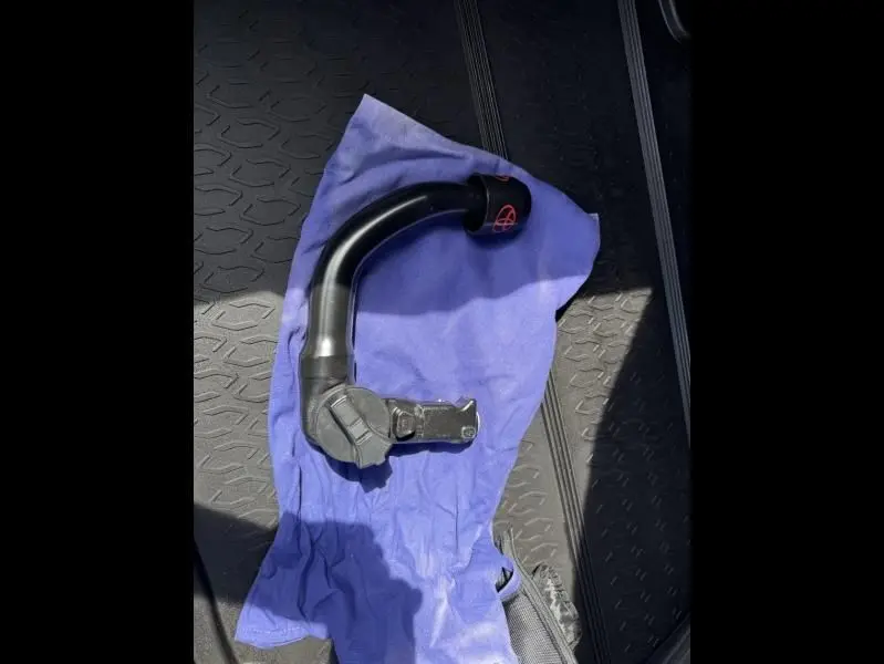 Vue rapprochée d'une pièce noire posée sur un chiffon bleu dans le coffre d'un Toyota C-HR Hybride 2024 bleu persan.
