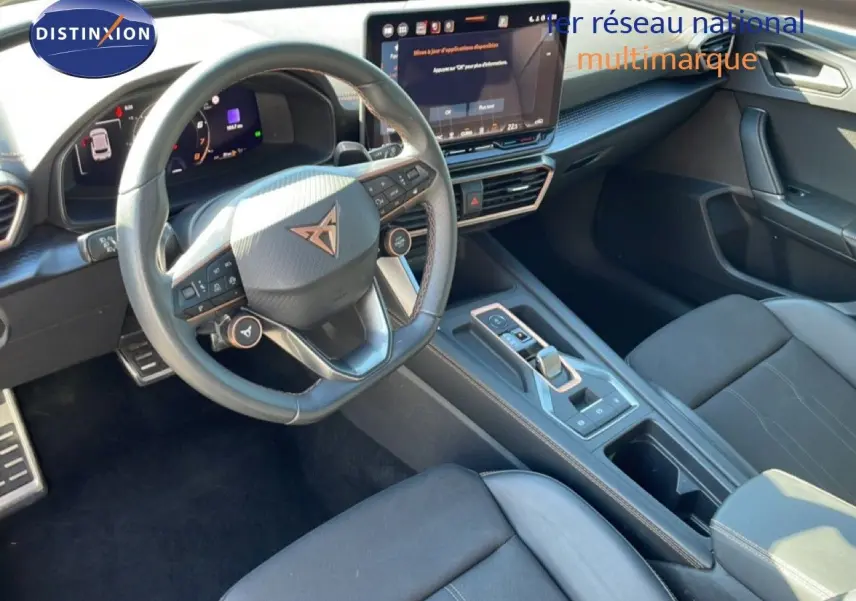 Vue intérieure de face côté conducteur du tableau de bord et volant cuir noir de la CUPRA Leon 1.5 eTSI 2025.