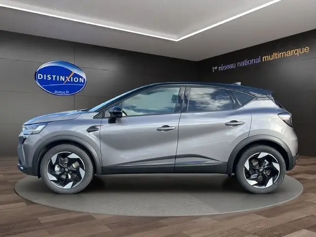 Profil côté gauche du Renault Captur 2025 gris foncé, avec jantes distinctives et lignes modernes visibles en showroom.