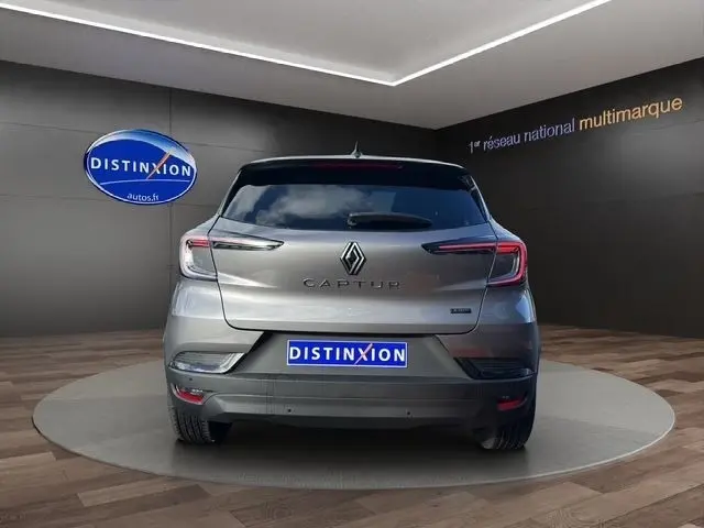 Vue arrière d'un Renault Captur gris foncé 2025 exposé en showroom avec logo Distinxion visible sur le mur.
