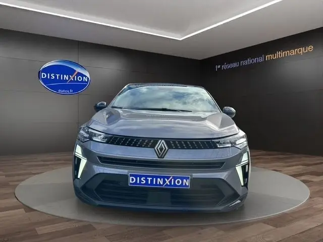 Vue de face d’un Renault Captur Techno full hybrid gris foncé, avec éclairage LED distinctif et logo Renault bien visible.