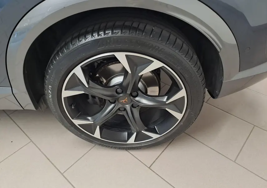 Gros plan sur la roue avant droite du CUPRA Formentor gris magnétique, avec jante noire et détails argentés.