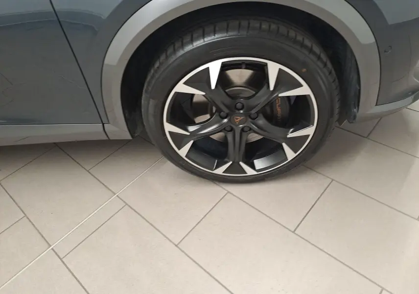 Gros plan sur la roue avant gauche du CUPRA Formentor gris magnétique avec jante noire et détails argentés.