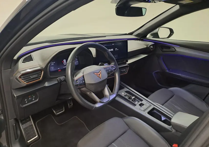 Intérieur avant droit du CUPRA Formentor 1.4 e-HYBRID 245 DSG6 VZ 2024 avec éclairage d’ambiance violet et volant multifonction.