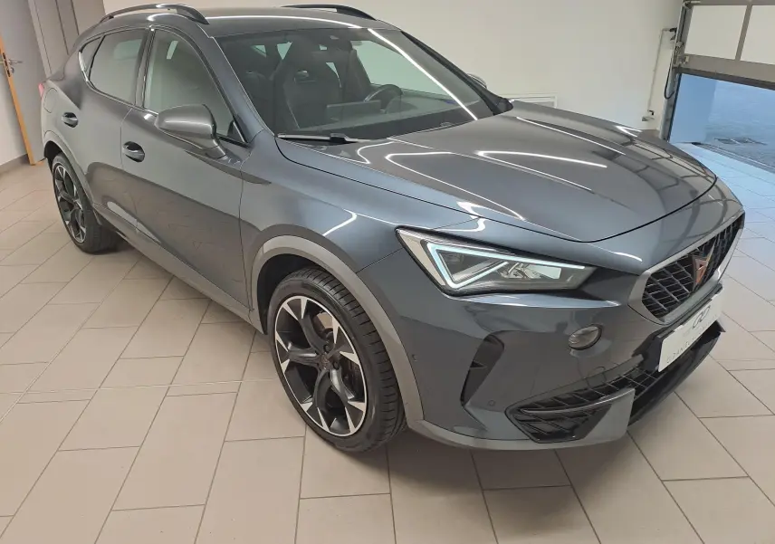 Vue 3/4 avant droit du CUPRA Formentor 1.4 e-HYBRID 245 DSG6 VZ en gris magnétique métallisé, intérieur visible.
