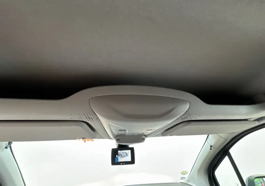 Vue intérieure avant du Peugeot Partner blanc, avec écran de caméra de recul suspendu au plafond.