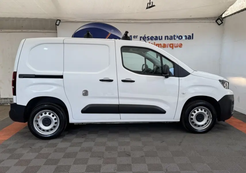Vue de profil côté gauche d’un utilitaire Peugeot Partner blanc avec porte latérale coulissante et jantes acier.