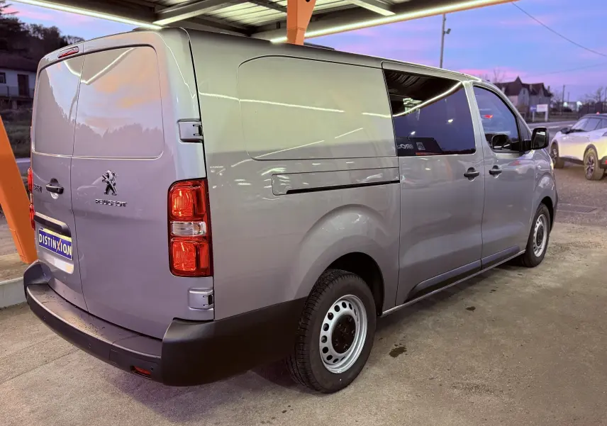 Vue 3/4 arrière droite d'un Peugeot Expert Cabine Approfondie gris Artense métal avec vitres teintées et jantes acier.