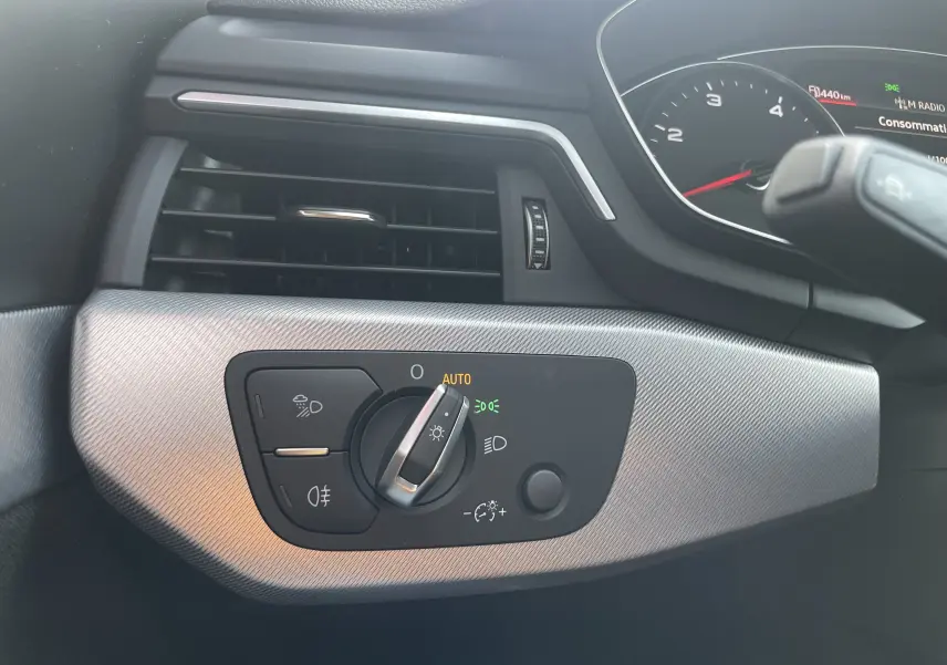 Détail du tableau de bord côté gauche de l'Audi A4 Avant 40 TDI blanc, avec commande d'éclairage en position auto.
