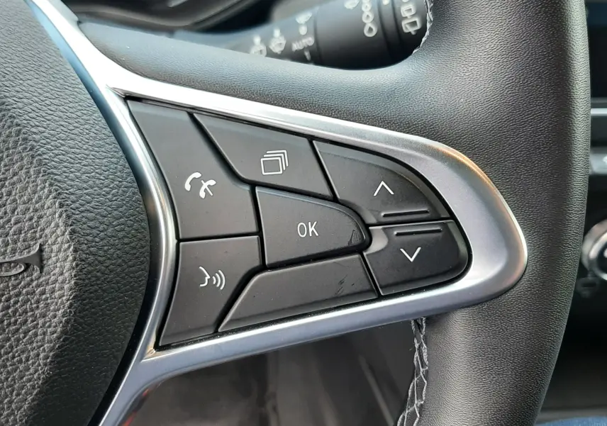 Gros plan sur les commandes multifonctions côté droit du volant cuir de la Renault Clio V gris titanium 2021.