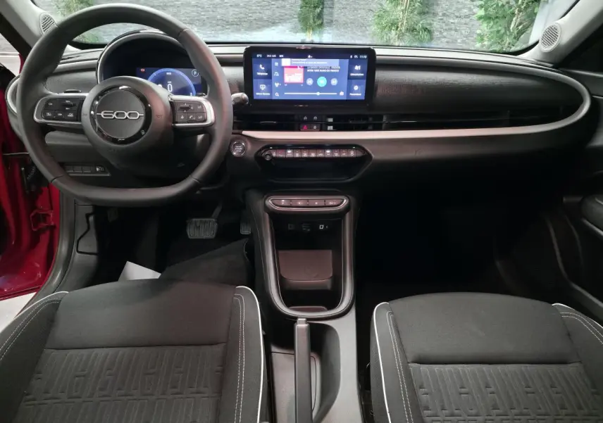 Intérieur noir de la FIAT 600 2024, vue avant du tableau de bord avec écran tactile et volant 600 central.