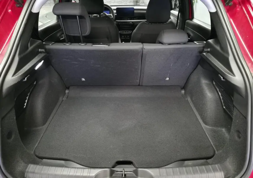 Coffre ouvert d'une FIAT 600 rouge 2024, vue arrière montrant banquette arrière et plancher de coffre modulable noir.