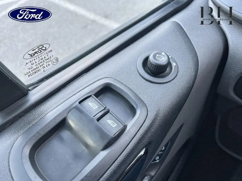 Gros plan sur les commandes des vitres et rétroviseurs côté conducteur du Ford Transit Custom bleu azur métallisé 2023.