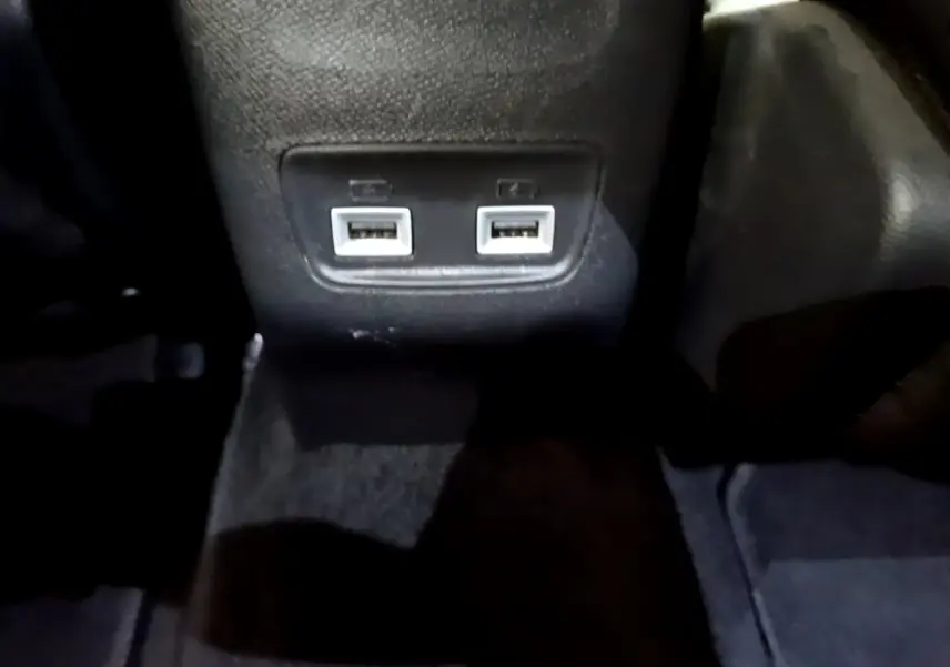 Gros plan sur les deux ports USB arrière intégrés au tunnel central du Peugeot 2008 PureTech 130 orange de 2021.