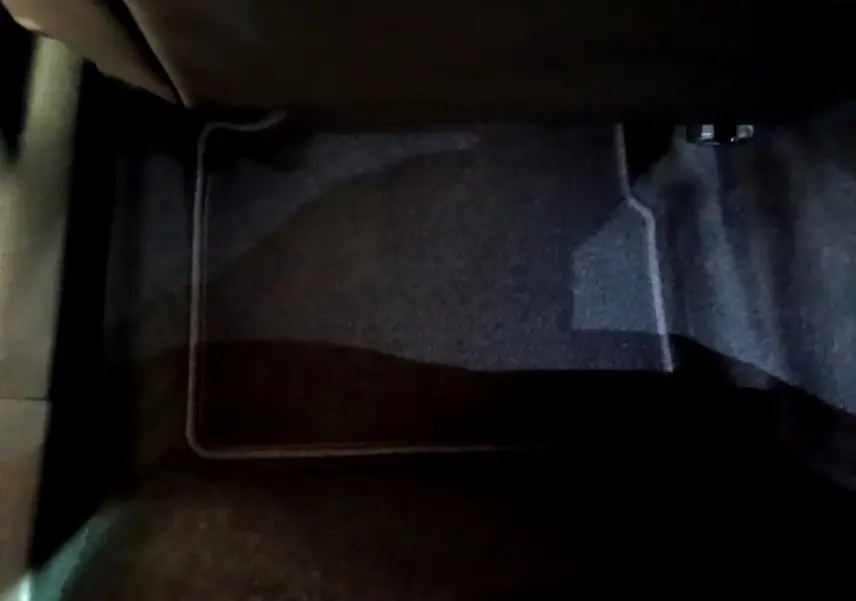 Vue rapprochée du tapis de sol noir côté passager avant du Peugeot 2008 orange 2021 PureTech 130 Allure Business.