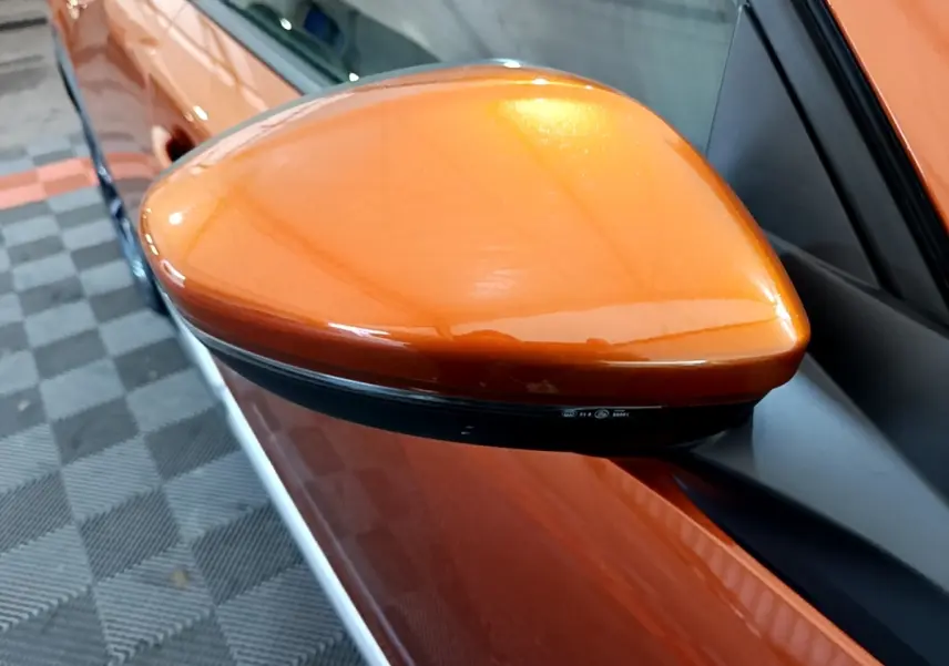 Rétroviseur côté gauche orange métallisé de la Peugeot 2008 PureTech 130, vue rapprochée sur la portière.