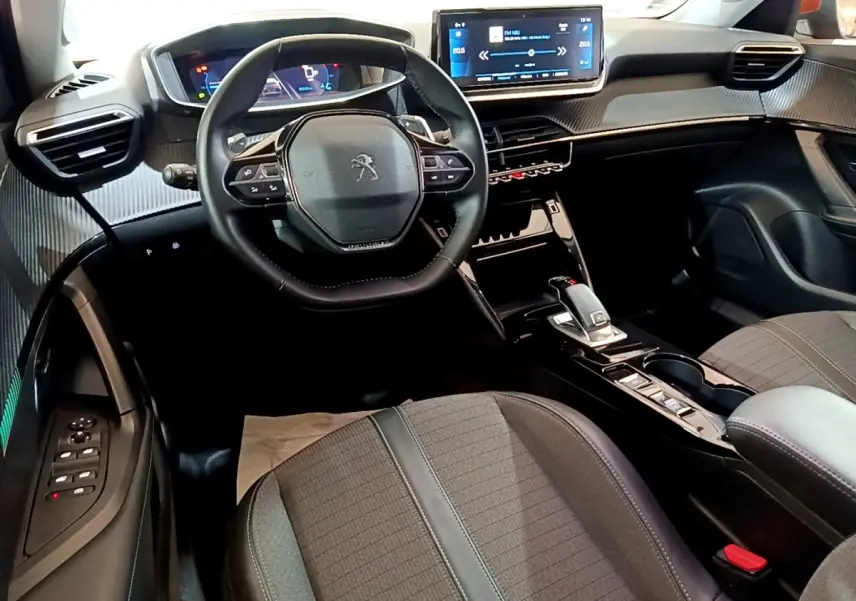 Vue intérieure avant du Peugeot 2008 avec volant cuir, écran tactile 10 pouces et sellerie tissu gris.