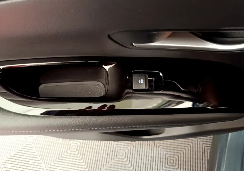 Détail de la commande de verrouillage de porte sur la portière côté conducteur d’un Hyundai Tucson bleu 2023.