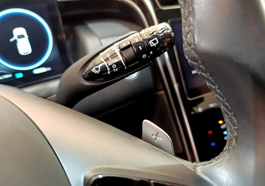 Gros plan sur la manette de commande des essuie-glaces côté gauche du volant cuir du Hyundai Tucson bleu 2023.