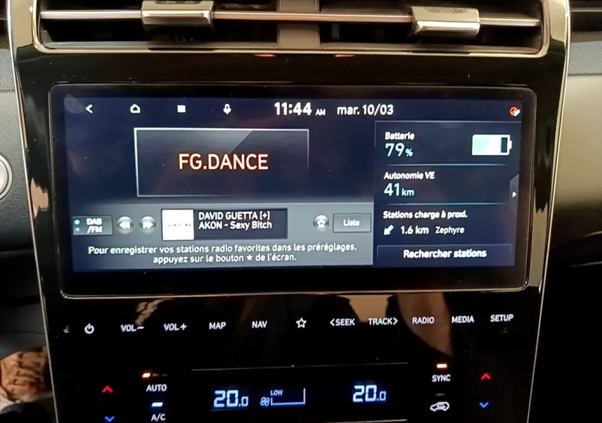 Écran tactile central du Hyundai Tucson bleu 2023 affichant radio et autonomie batterie à 79%