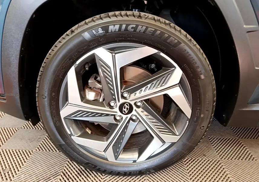 Gros plan sur la roue avant droite du Hyundai Tucson bleu 2023 avec jante alliage et pneu Michelin.