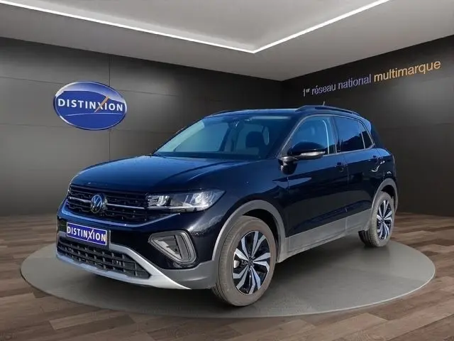 Vue 3/4 avant d'un Volkswagen T-Cross noir 2025, avec calandre noire et jantes alliage distinctives, en showroom.