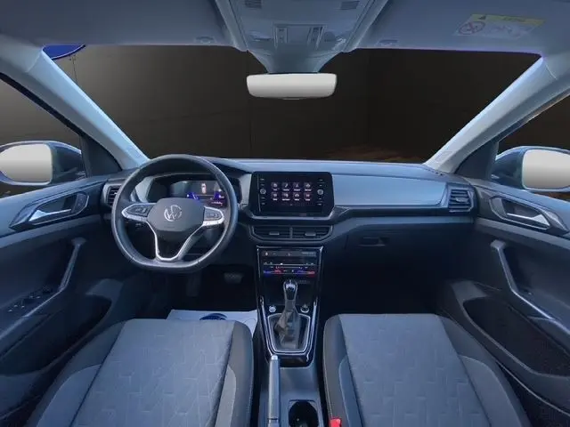 Vue intérieure frontale du Volkswagen T-Cross 2025 noir, avec tableau de bord moderne et écran tactile central.
