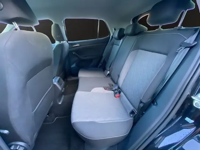 Vue intérieure côté droit des sièges arrière gris du Volkswagen T-Cross noir, montrant la banquette 3 places et les appuie-têtes.