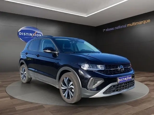 Volkswagen T-Cross noir vue 3/4 avant droit en intérieur, avec calandre et phares LED distinctifs.