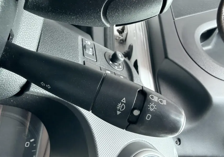 Gros plan sur la commande des phares et clignotants côté gauche du tableau de bord d'un Citroën Berlingo blanc 2016.