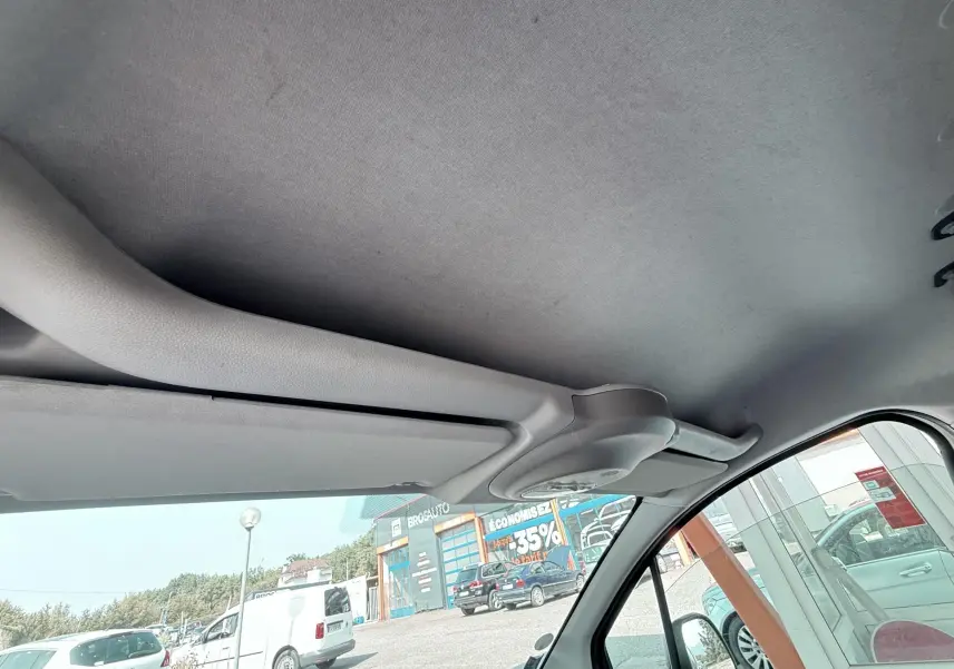 Vue intérieure côté conducteur du toit et pare-soleil d’un Citroën Berlingo 2016, tissu gris et intérieur clair.