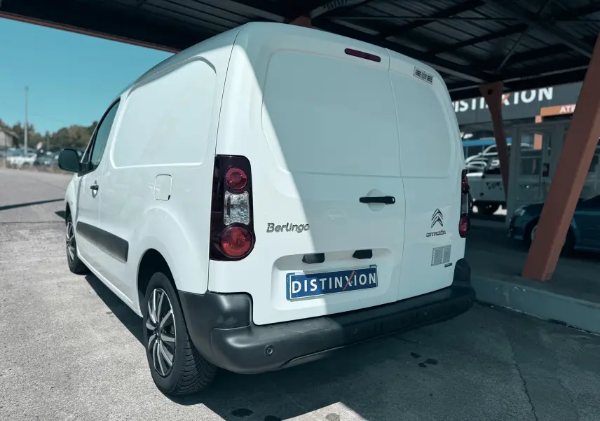 Vue 3/4 arrière droite d’un utilitaire Citroën Berlingo blanc avec logo et plaque Distinxion visible.