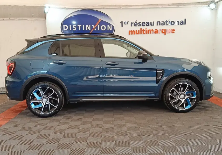 Vue de profil côté gauche d'un SUV Link & Co 01 hybride rechargeable bleu avec jantes bicolores et toit noir.